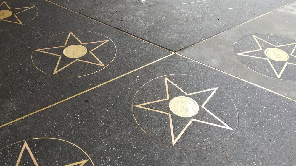 Playwrights’ Sidewalk outside of the Lucille Lortel theatre. Gold star plaques are embedded into black asphalt.
